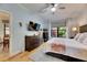 Spacious bedroom with a ceiling fan, TV, a view of the landscaped yard, and hardwood floors at 329 Laurel Falls Dr, Apollo Beach, FL 33572