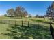 Large, fenced backyard with mature trees and a verdant lawn at 34411 Sahalee Loop, Dade City, FL 33525