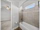 Bright bathroom featuring a tub with tiled wall and view to bedroom with ceiling fan at 34411 Sahalee Loop, Dade City, FL 33525