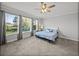 A serene bedroom features carpet, three large windows, and ceiling fan at 34411 Sahalee Loop, Dade City, FL 33525