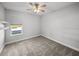 Clean, carpeted bedroom with a ceiling fan, window, and built-in shelving at 34411 Sahalee Loop, Dade City, FL 33525