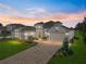 Stunning single-Gathering home showcasing a brick driveway, lush landscaping, and a warm and inviting facade at 34411 Sahalee Loop, Dade City, FL 33525