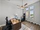 Bright home office featuring a ceiling fan, desk area, and exercise bike with large windows at 34411 Sahalee Loop, Dade City, FL 33525