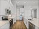 A well-lit kitchen features stainless appliances, white cabinets, wood floors, and a stylish pendant light at 34411 Sahalee Loop, Dade City, FL 33525