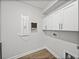 Laundry room features white cabinets and a utility sink for efficient cleaning at 34411 Sahalee Loop, Dade City, FL 33525