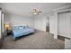 Spacious main bedroom with a ceiling fan, large closet, and plush carpet floors at 34411 Sahalee Loop, Dade City, FL 33525