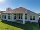 Beautiful rear exterior of home with many windows, covered patio, and lush green yard at 34411 Sahalee Loop, Dade City, FL 33525