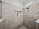 Walk-in shower with gray tiles, mosaic accents, and recessed shelving at 34411 Sahalee Loop, Dade City, FL 33525