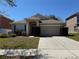 Charming single-story home with a well-manicured lawn, blue accents, and an attached two-car garage at 3616 Beaumont Loop, Spring Hill, FL 34609