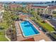 Aerial view of community pool with lounge chairs, palm trees, townhouses, and parking at 442 Sandy Hook Rd, Treasure Island, FL 33706