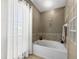 Window bathes a large soaking tub in natural light in this bathroom at 442 Sandy Hook Rd, Treasure Island, FL 33706