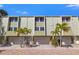 Charming townhome with light green siding, multi-car garage, and well-manicured landscaping at 442 Sandy Hook Rd, Treasure Island, FL 33706