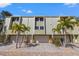 Exterior view of attractive townhouses with garages, patios, and green landscaping at 442 Sandy Hook Rd, Treasure Island, FL 33706