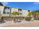 Inviting townhome with charming curb appeal, showcasing lush palms and a convenient two-car garage at 442 Sandy Hook Rd, Treasure Island, FL 33706