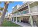 Multi-story condo building with patios, stairs and a grassy yard area at 442 Sandy Hook Rd, Treasure Island, FL 33706