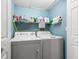 A view of the laundry room featuring a washer, dryer, and storage shelf at 442 Sandy Hook Rd, Treasure Island, FL 33706