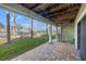 Covered outdoor patio featuring brick pavers, a spiral staircase, and tennis court views at 442 Sandy Hook Rd, Treasure Island, FL 33706