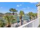 Balcony view overlooking tennis courts, palm trees, and a lake at 442 Sandy Hook Rd, Treasure Island, FL 33706