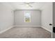 A bedroom with grey carpet and paint, a window, and a ceiling fan at 445 29Th N Ave, St Petersburg, FL 33704