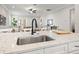 Kitchen with stainless steel sink, granite counters, white cabinets, and views of the living room at 445 29Th N Ave, St Petersburg, FL 33704