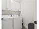 Practical laundry room with washer, dryer, and upper cabinets for ample storage at 445 29Th N Ave, St Petersburg, FL 33704