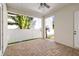 Covered outdoor patio with neutral brick flooring, overlooking a white fence and tropical landscaping at 445 29Th N Ave, St Petersburg, FL 33704