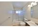 Bathroom featuring tiled shower-tub combo with glass doors, a modern toilet, and a simple vanity at 473 Fairfax Ln, Apollo Beach, FL 33572