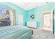 Bedroom with cool blue walls, carpet, a large window, and dresser at 5384 Mira Vista Dr, Palm Harbor, FL 34685