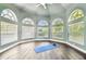 Light-filled bonus room with many windows, light green walls and wood floors at 5384 Mira Vista Dr, Palm Harbor, FL 34685