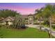 Stunning home features a circular driveway, well-manicured lawn, and beautiful landscaping, including mature palm trees at 5384 Mira Vista Dr, Palm Harbor, FL 34685