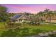 Beautiful home with a well-maintained lawn, lush landscaping, and a solar panel roof at 5384 Mira Vista Dr, Palm Harbor, FL 34685