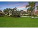 Beautiful home with well-manicured lawn, mature trees, and a circular driveway at 5384 Mira Vista Dr, Palm Harbor, FL 34685