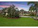 Imposing home with manicured lawn, lush landscaping, and a welcoming circular driveway at 5384 Mira Vista Dr, Palm Harbor, FL 34685