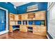 Home office with custom built-ins, hardwood floors, and bright blue accent wall at 5384 Mira Vista Dr, Palm Harbor, FL 34685