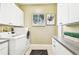 Bright laundry room featuring a modern washer and dryer, ample counter space, and plenty of storage cabinets at 5384 Mira Vista Dr, Palm Harbor, FL 34685