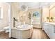 Luxurious main bathroom featuring modern fixtures, tiled walls, soaking tub and step-in shower at 5384 Mira Vista Dr, Palm Harbor, FL 34685