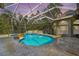 Enclosed pool area features a jacuzzi, waterfall feature, tiled flooring and a screened enclosure at 5384 Mira Vista Dr, Palm Harbor, FL 34685