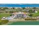 Aerial view of a condo building near the water with a pool, surrounded by golf and other condos at 5700 Escondida S Blvd # 506, St Petersburg, FL 33715