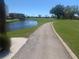 Scenic view of condo community with lush golf course, water feature and winding pathway at 5700 Escondida S Blvd # 506, St Petersburg, FL 33715