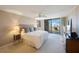Sunlit main bedroom featuring a king bed, private balcony, fireplace, and modern furniture at 5700 Escondida S Blvd # 506, St Petersburg, FL 33715