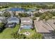 Aerial view of a home with a private pool, fire pit, and lake views in a lush, green community at 6617 Park Strand Dr, Apollo Beach, FL 33572
