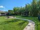 Large, manicured backyard with a fire pit, trampoline, lush greenery, and a winding stone path at 6617 Park Strand Dr, Apollo Beach, FL 33572