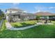 Spacious backyard with a screened pool, fire pit, outdoor seating, and lush landscaping at 6617 Park Strand Dr, Apollo Beach, FL 33572