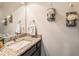 Elegant half-bathroom with granite countertop, modern sink, and decorative wall art at 6617 Park Strand Dr, Apollo Beach, FL 33572
