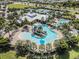 Aerial view of community pool area with waterslides, seating, and surrounded by palm trees at 6617 Park Strand Dr, Apollo Beach, FL 33572