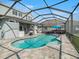 Expansive backyard with a sparkling pool, screened enclosure, hot tub, and outdoor kitchen at 6617 Park Strand Dr, Apollo Beach, FL 33572