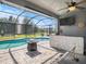 Inviting screened-in pool area with a swim-up bar, fire pit, and ample seating for entertaining at 6617 Park Strand Dr, Apollo Beach, FL 33572