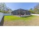 Spacious backyard with white fence surrounds, screened pool enclosure, and well-maintained lawn at 6644 Par Ct, Wesley Chapel, FL 33544