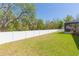 Expansive fenced backyard with lush green grass offers privacy and room for recreation at 6644 Par Ct, Wesley Chapel, FL 33544
