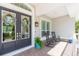 Inviting front porch with rocking chairs and double doors adorned with wreaths, perfect for relaxing at 6644 Par Ct, Wesley Chapel, FL 33544